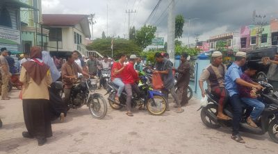 Teks: Pembagian di Halaman Masjid Suhada, Karang Baru