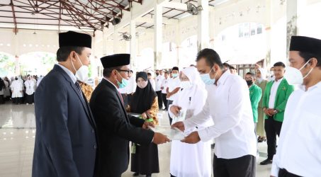 Teks : Rektor memberikan penghargaan kepada civitas akademika yang berprestasi.