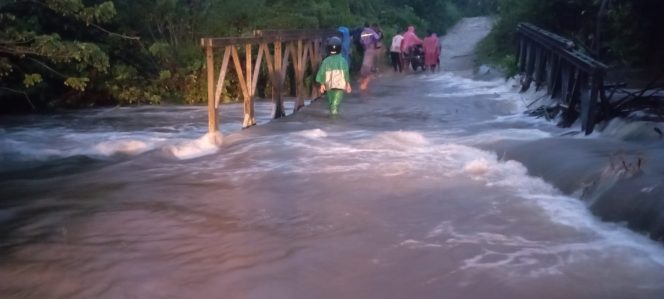 
 Foto: Warga melintas di jembatan yang terendam banjir.