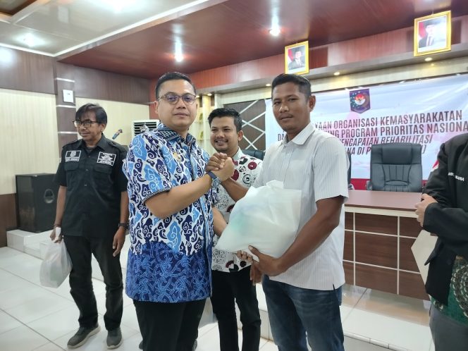 
 Wali Kota Langsa Jeffry Sentana menyerahkan bantuan sembako kepada salah seorang perwakilan ormas.