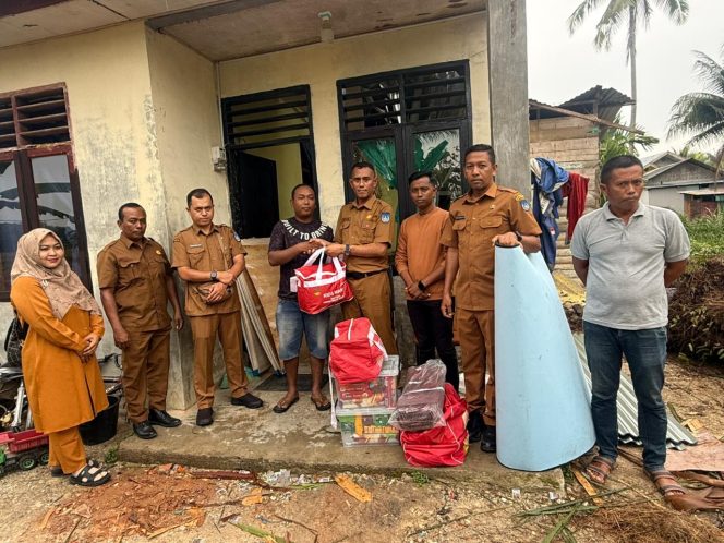 
 Kadinsos beserta jajaran menyerahkan bantuan kepada korban rumah tertimpa pohon di Gampong Alue Pineung Timue.