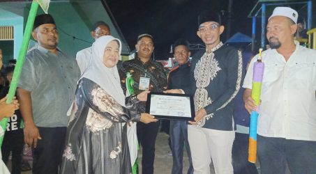 Pj Geuchik Gampong Baroh Langsa Lama Iwan Apriandi menyerahkan piagam kepada Kepala Sekolah SDN 2 Alue Dua atas partisipasi Grup Drumband memeriahkan pawai obor.