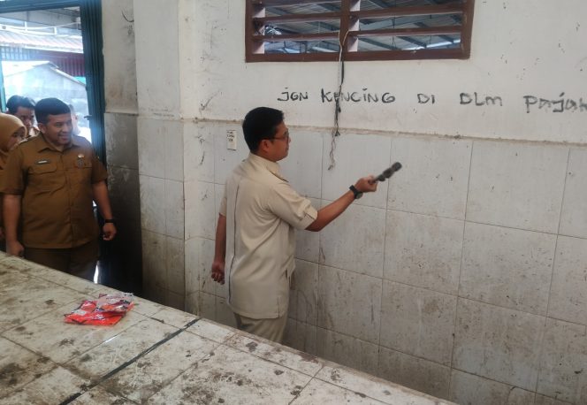 
 Wali Kota Langsa Jeffry Sentana memukul palu secara simbolis untuk merobohkan dinding pasar ikan yang tidak bermanfaat.